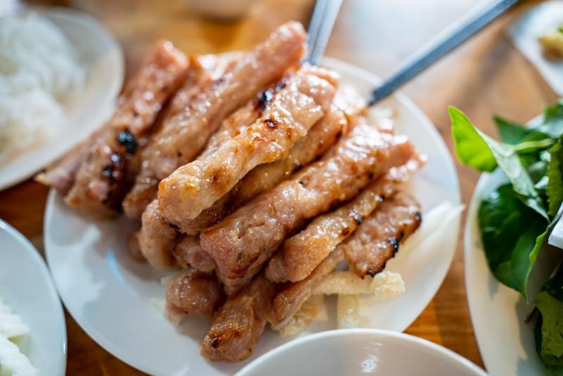 Một chiếc vali, mũ rộng vành, kem chống nắng và kính râm đặt cạnh nhau trên nền cát vàng, gợi ý về một chuyến du lịch biển Mũi Né đầy nắng và gió.